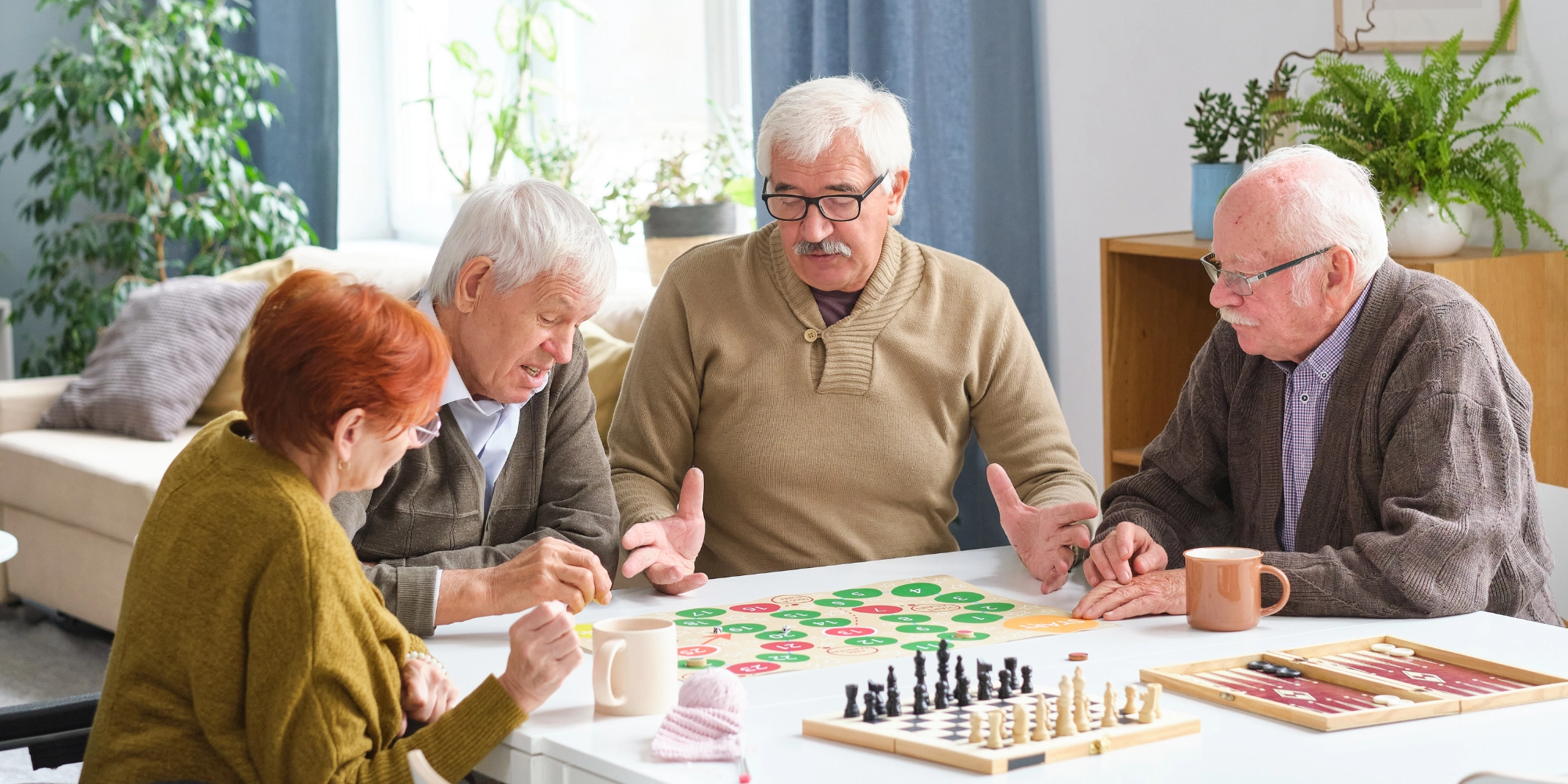 Older adults enjoying activities in a communal living space at a residential care facility.